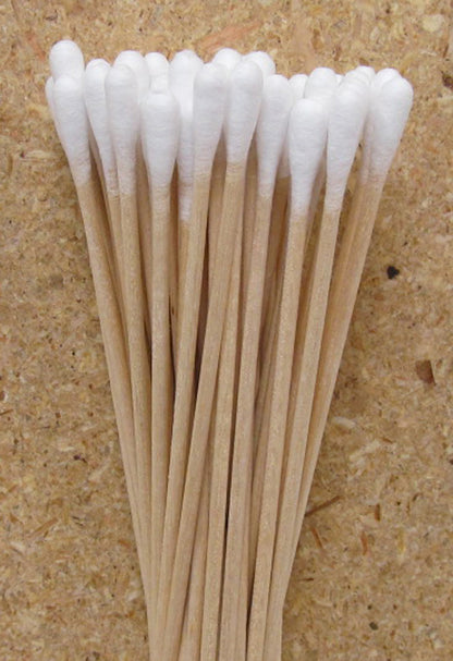 Close up view of low lint cotton swabs on a  light tan background